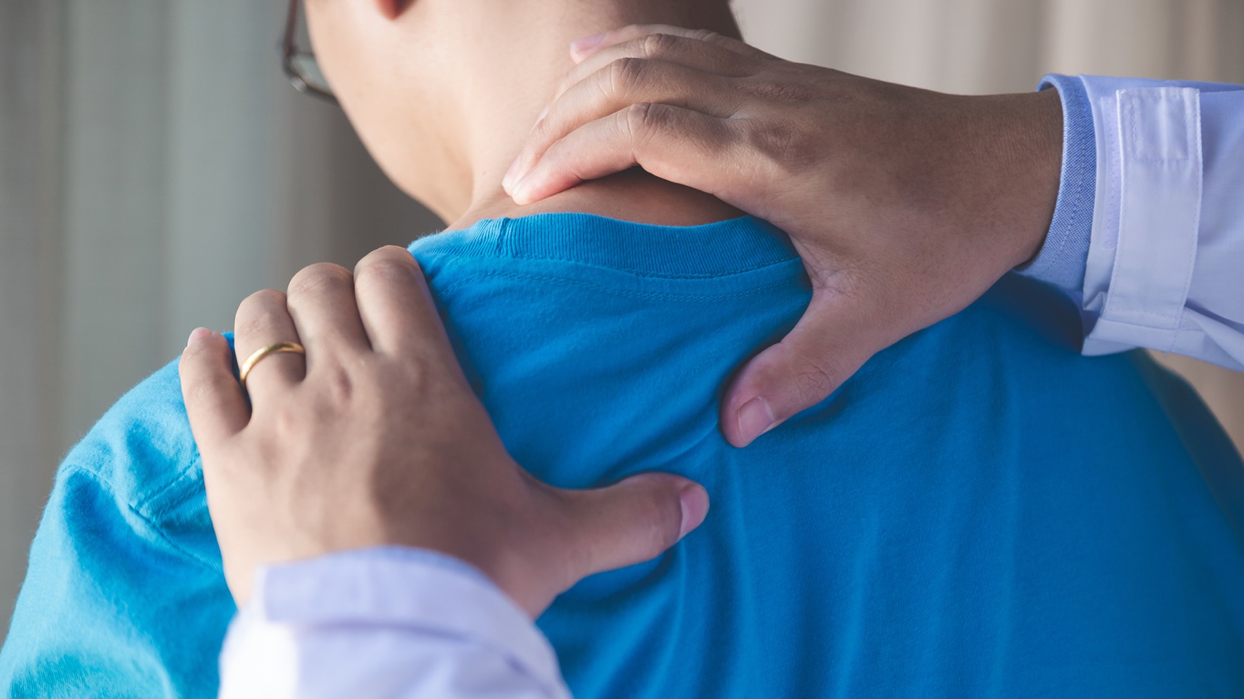 Physiotherapist assessing a patient's neck and shoulder